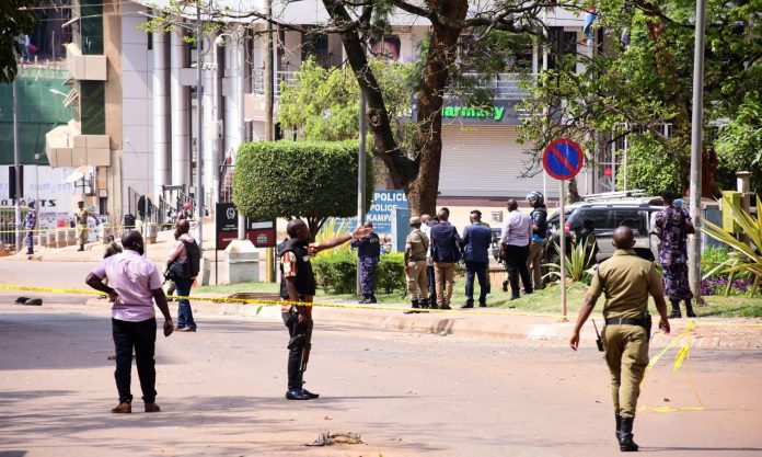 Ugandan police and explosion experts secure the scene of a blast in Kampala
